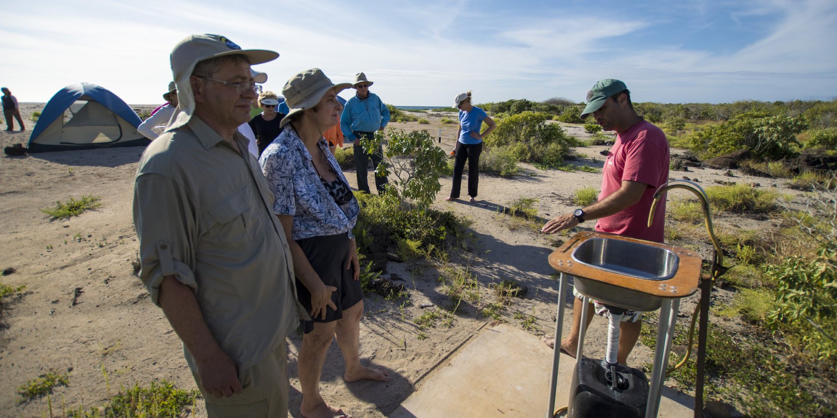 A local guide in the Galapagos Islands going over water usage at an oceanfront eco-camp.