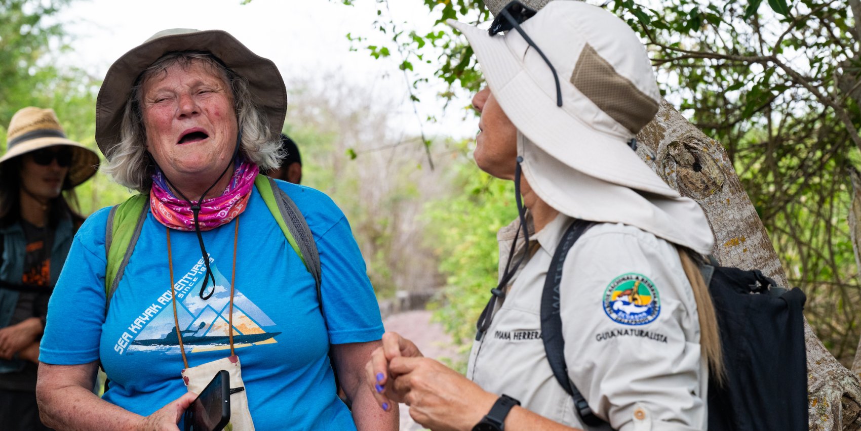 A tourist and local Galapagos tour guide learning, laughing, and smiling at one another
